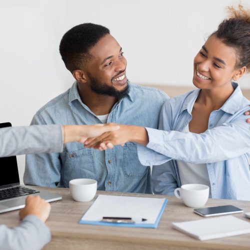 cheerful-afro-spouses-and-finansial-counselor-handshaking-in-office.jpg